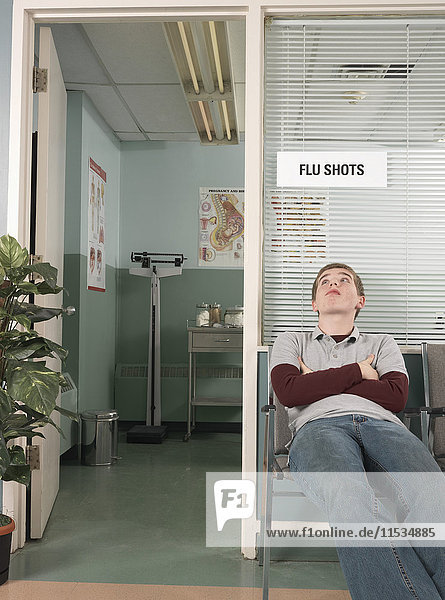 Junge im Teenageralter  der im Büro des Arztes wartet