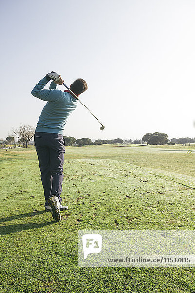 Golfer hitting a golf ball on a golf course