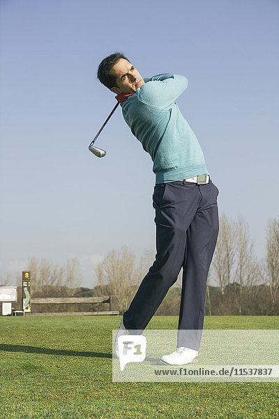 Golfer hitting a golf ball in a golf course