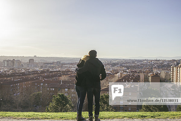 Spain  Madrid  back view of young couple in love on a hill looking to the city