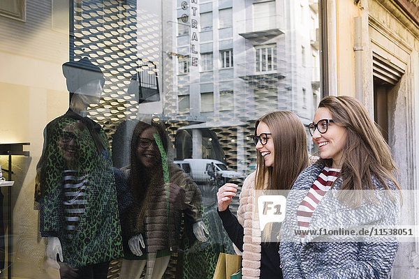 Italien  Belluno  zwei junge Frauen  die auf die Schaufensterdekoration eines Modegeschäfts schauen