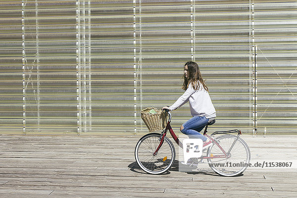Junge Frau auf dem Fahrrad mit Korb