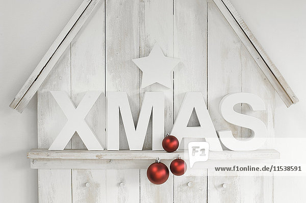 Weihnachtsdekoration mit Stern  Christbaumkugeln und Buchstaben  die das Wort'Weihnachten' bilden.