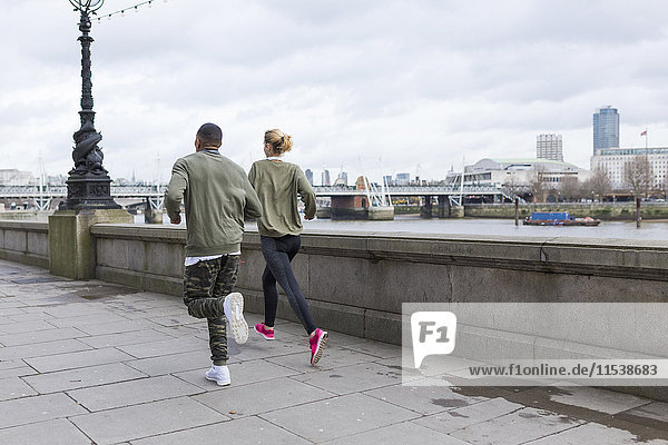 UK  London  Mann und Frau laufen auf dem Riverwalk