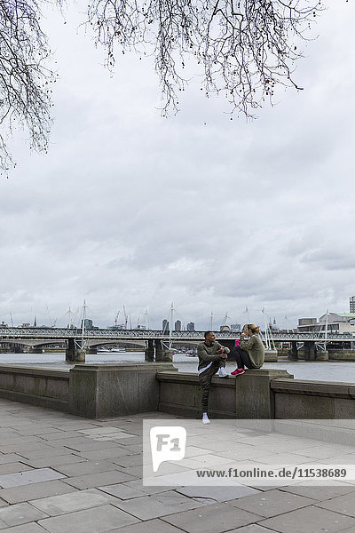 UK  London  two runners relaxing at riverwalk