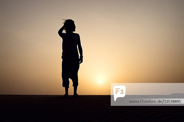 Silhouette of man standing on dune