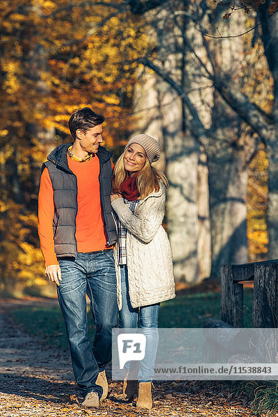 Happy couple strolling in autumn in a forest