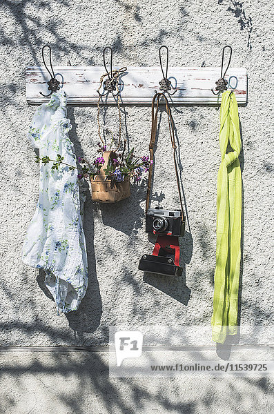 Sping items and old camera on wall coat rack
