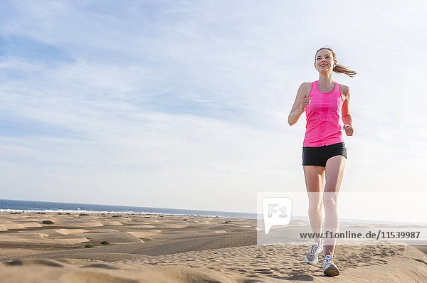 Junge Frau beim Joggen am Strand