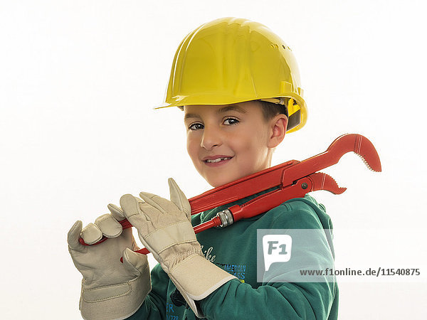 Portrait of boy with hard hat holding large pliers