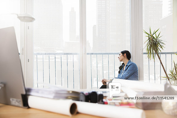 Woman in office looking out of window