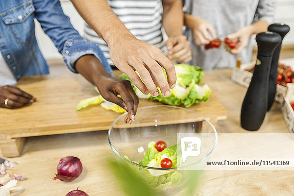 Hands over salad bowl in kitchen