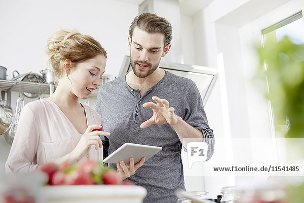 Couple looking at digital tablet in kitchen