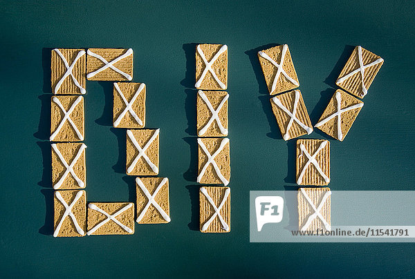 Buchstaben DIY aus Keksen mit Zuckerguss auf grünem Grund