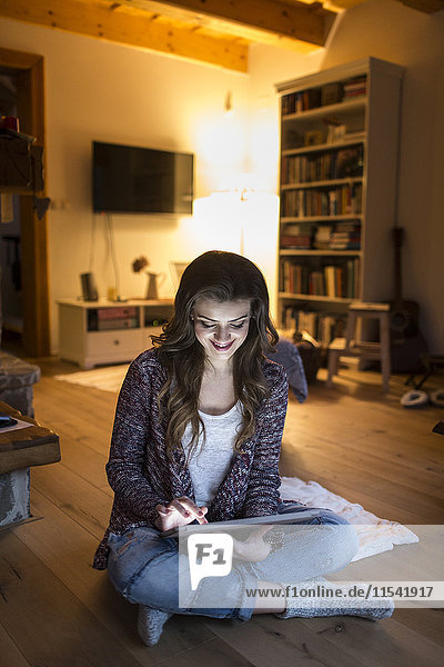 Young woman at home working with digital tablet