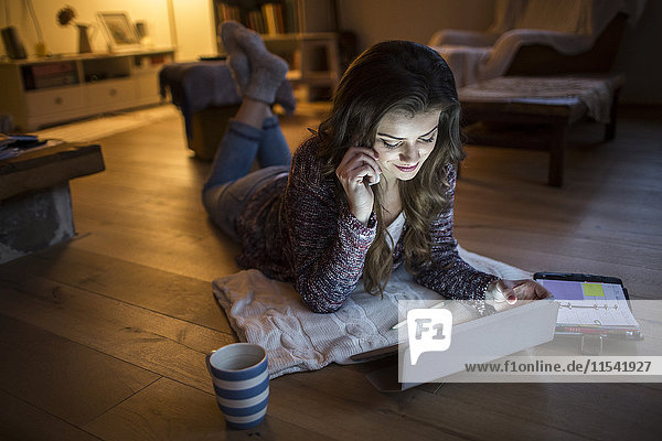 Junge Frau zu Hause bei der Arbeit mit dem digitalen Tablett