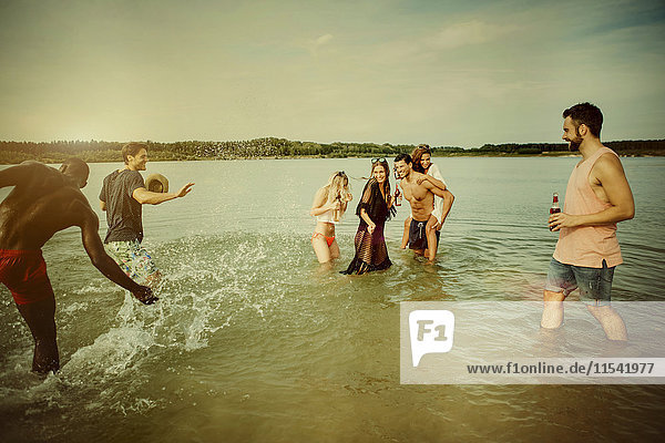 Germany  Haltern  group of friends standing in water of Lake Silbersee having fun together
