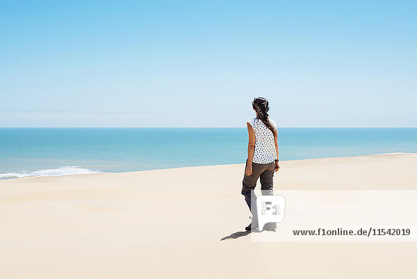 Namibia  Namib desert  Swakopmund  woman walking among the dunes of the desert to the sea