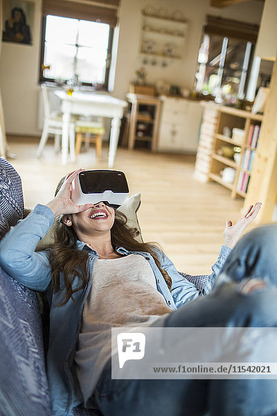 Junge Frau zu Hause mit Virtual Reality-Brille