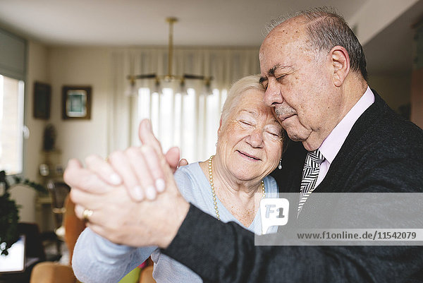 Senior couple dancing together at home