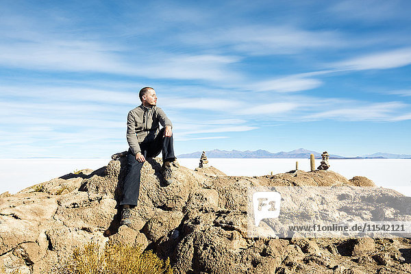 Bolivia  Atacama  Altiplano  Salar de Uyuni  man sitting on stone