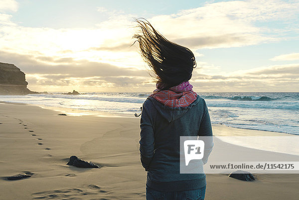 Spanien  Fuerteventura  El Cotillo  Rückansicht der Frau am Strand mit wehendem Haar