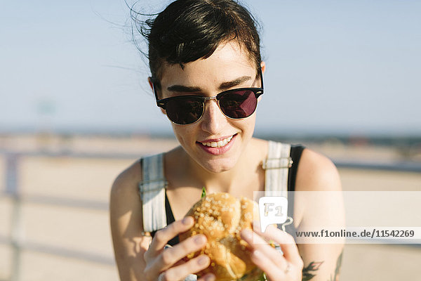 USA  New York  Coney Island  young woman eating a hamburger