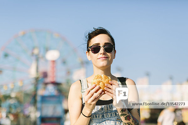 USA  New York  Coney Island  young woman eating a hamburger
