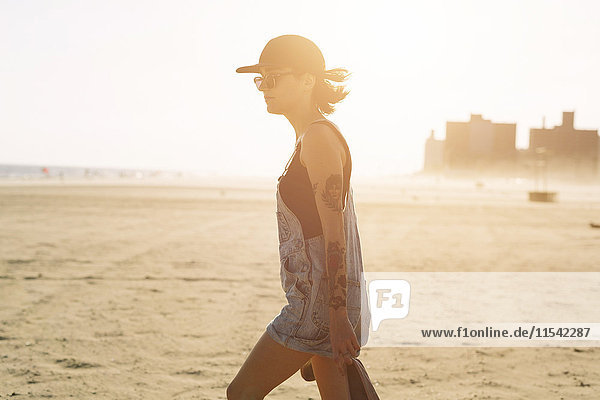 USA  New York  Coney Island  junge Frau am Strand bei Sonnenuntergang