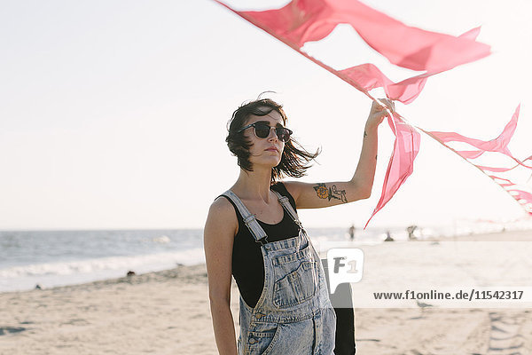 USA  New York  Coney Island  junge Frau mit roten Fahnen am Strand