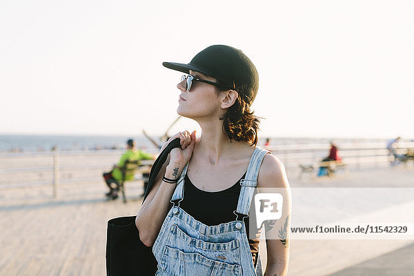 USA  New York  Coney Island  junge Frau an der Strandpromenade bei Sonnenuntergang