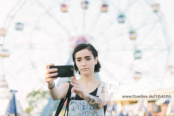 USA  New York  Coney Island  junge Frau  die im Vergnügungspark einen Selfie macht