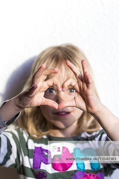 Little girl shaping heart with fingers