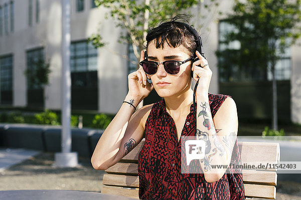 USA  New York City  Williamsburg  portrait of tattooed young woman with headphones