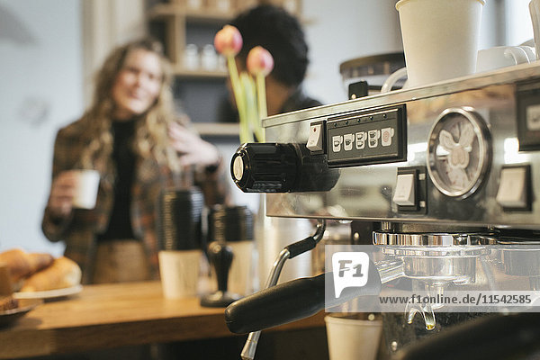 Kaffeemaschine und Menschen im Café