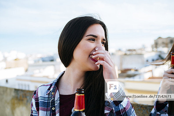 Spanien  Jerez de la Frontera  Porträt der lachenden jungen Frau mit Bierflasche