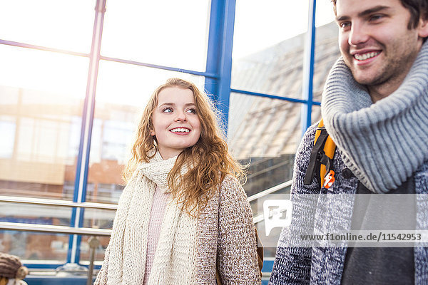 Lächelndes junges Paar am Bahnhof
