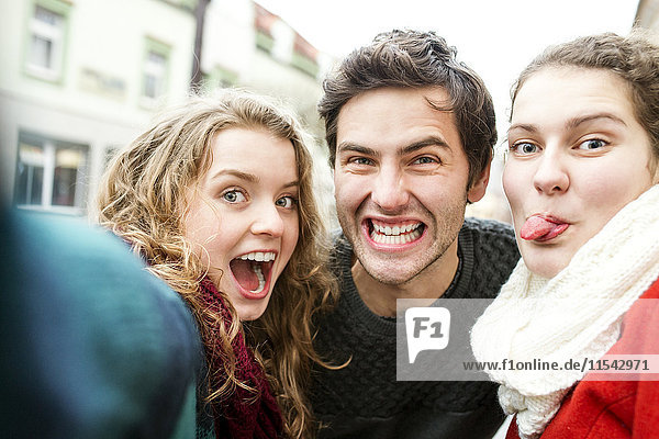 Drei verspielte Freunde  die einen Selfie nehmen.