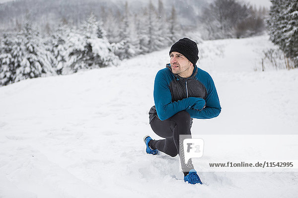 Mann beim Aufwärmen für Langlauf im Winter