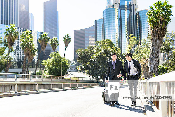USA,  Los Angeles,  zwei Geschäftsleute,  die mit Gepäck laufen