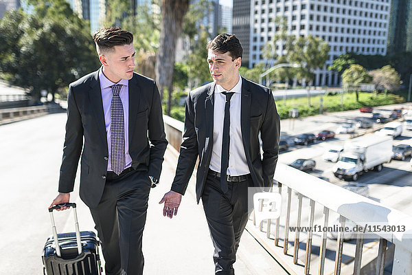 USA  Los Angeles  two businessmen walking with luggage