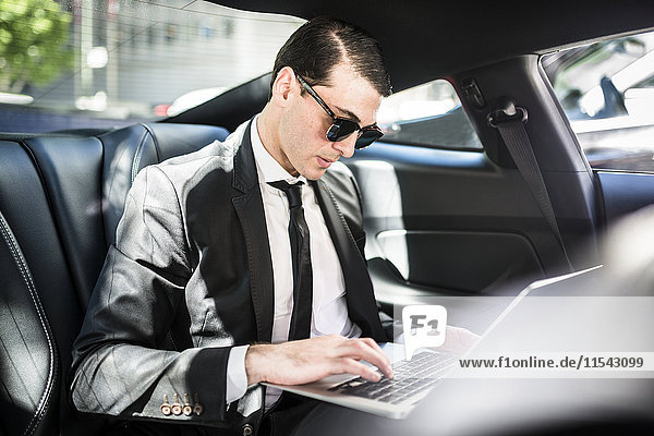 Businessman in car using laptop
