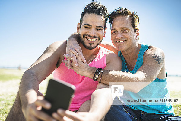 Gay couple taking selfie with smartphone