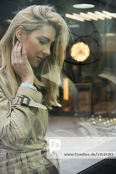 Young woman looking through window display