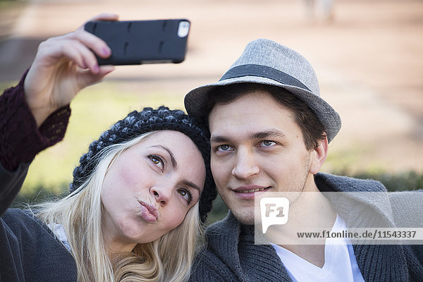 Porträt eines verliebten Paares  das sich selbst mit dem Smartphone fotografiert.