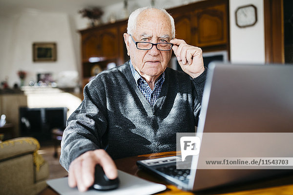 Porträt eines älteren Mannes mit Laptop zu Hause