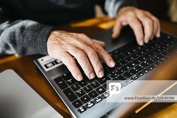 Hands of senior man using laptop  close-up