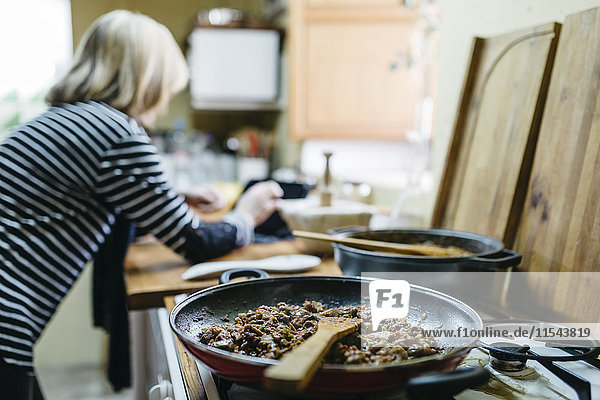 Woman using digital tablet while cooking