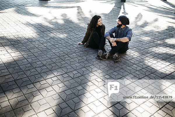 Spanien  Tarragona  Junges Paar beim Reden  im Schatten sitzend