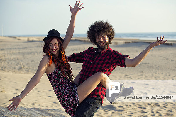 Spanien  Cádiz  Porträt eines jungen Paares mit Spaß am Strand